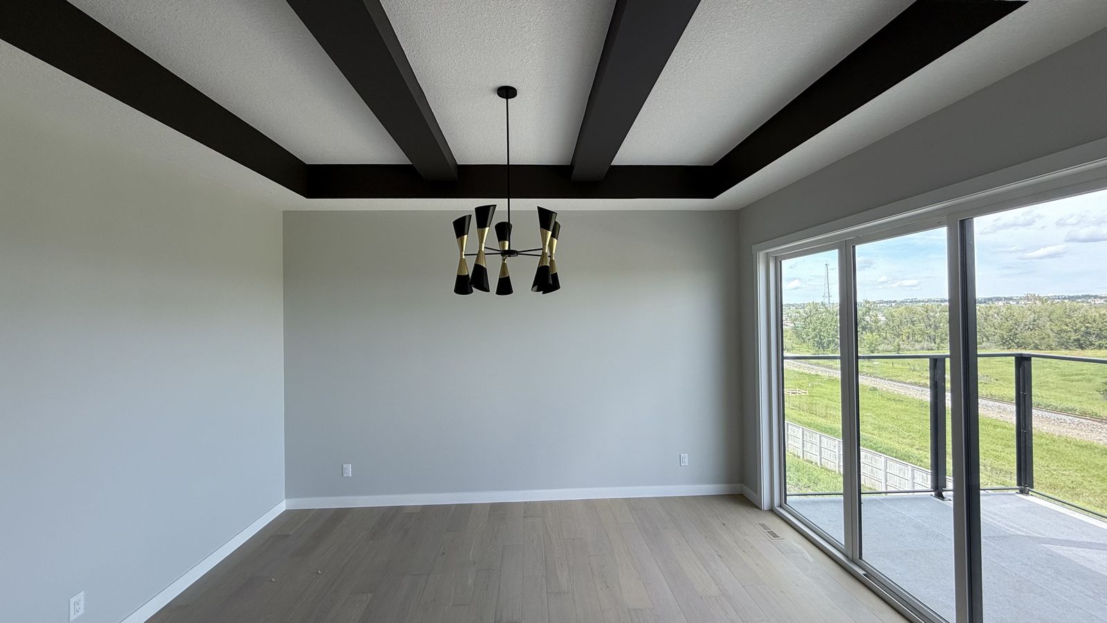 Dining room with black ceiling beams in an Alliston home in Cimarron, painted by Enteco