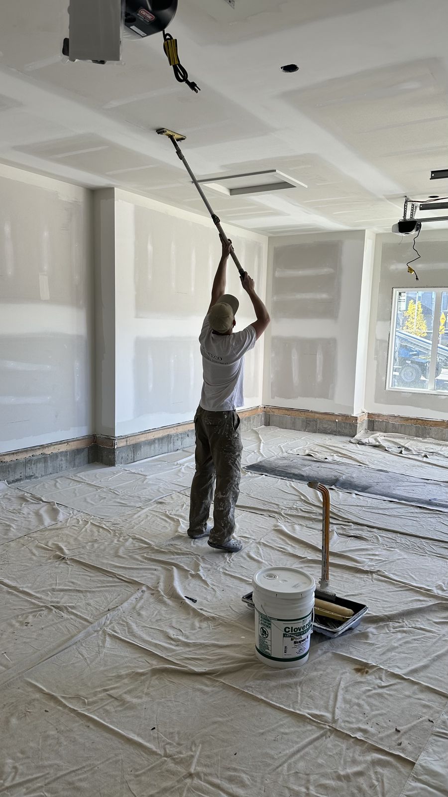 Enteco painter rolling a garage ceiling at an Alliston address in Cimarron, Okotoks