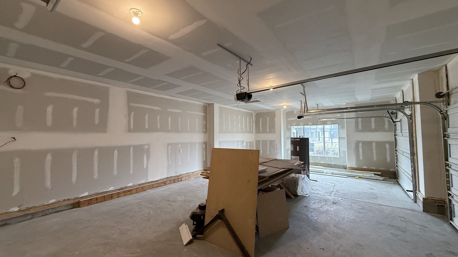 Unpainted garage with taped drywall in an Alliston home in Cimarron, before