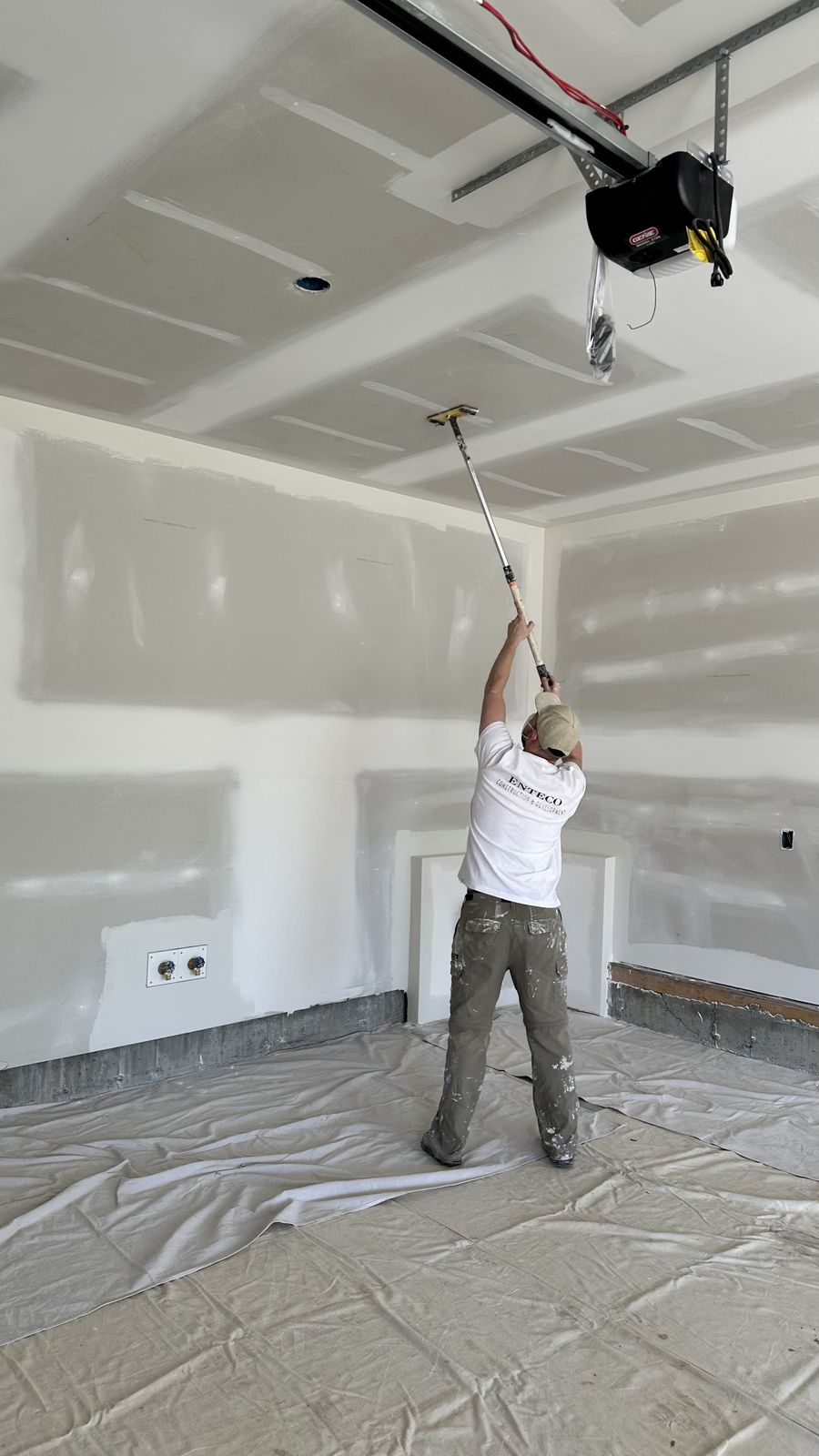 Enteco painter working overhead on a ceiling at an Alliston address in Cimarron