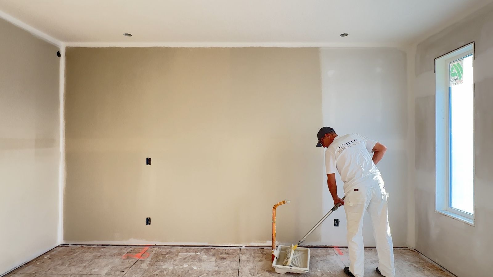 Enteco painter priming walls inside Alliston's new showhome in Chestermere