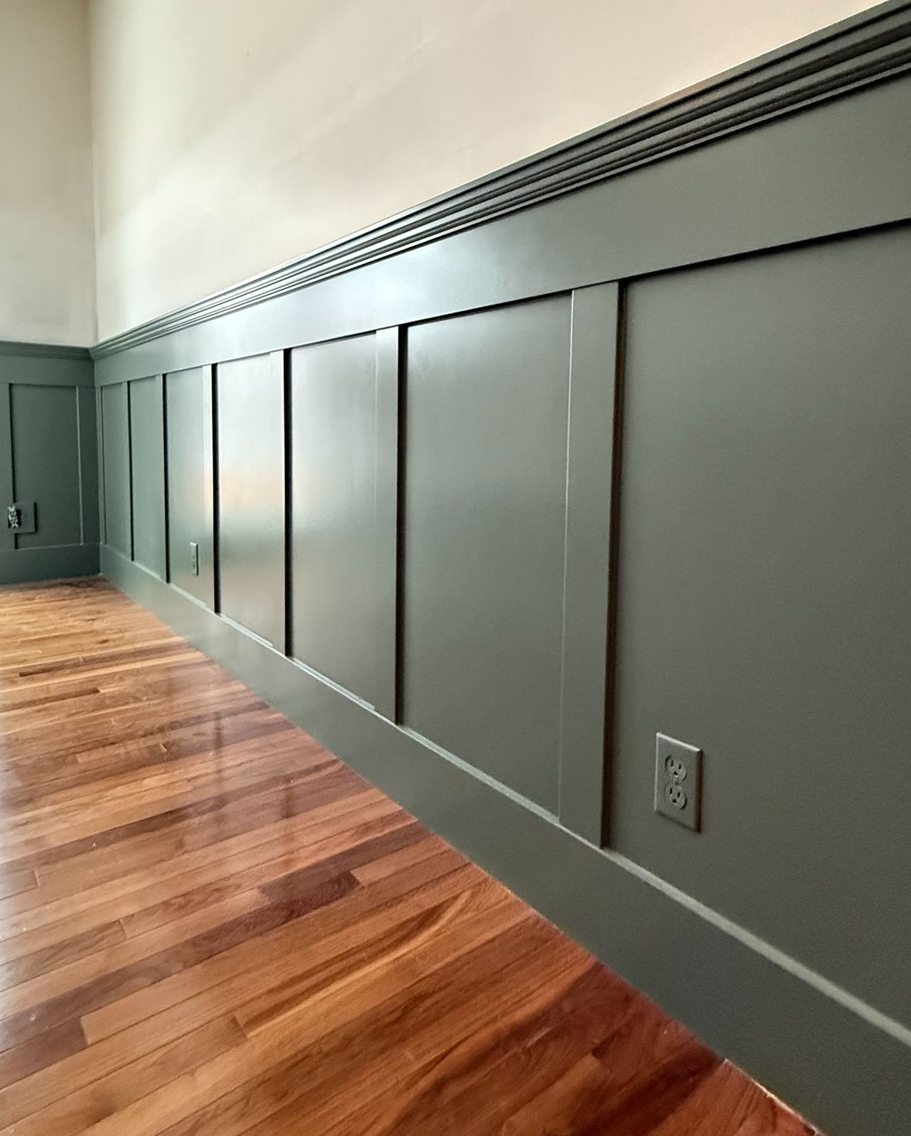 Bow Crescent hallway after renovation, dark wainscoting and wood floor
