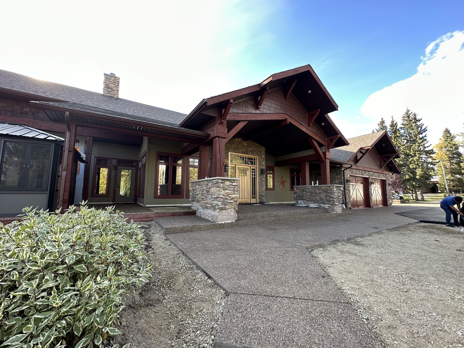 Same custom home exterior after repaint, deep burgundy trim