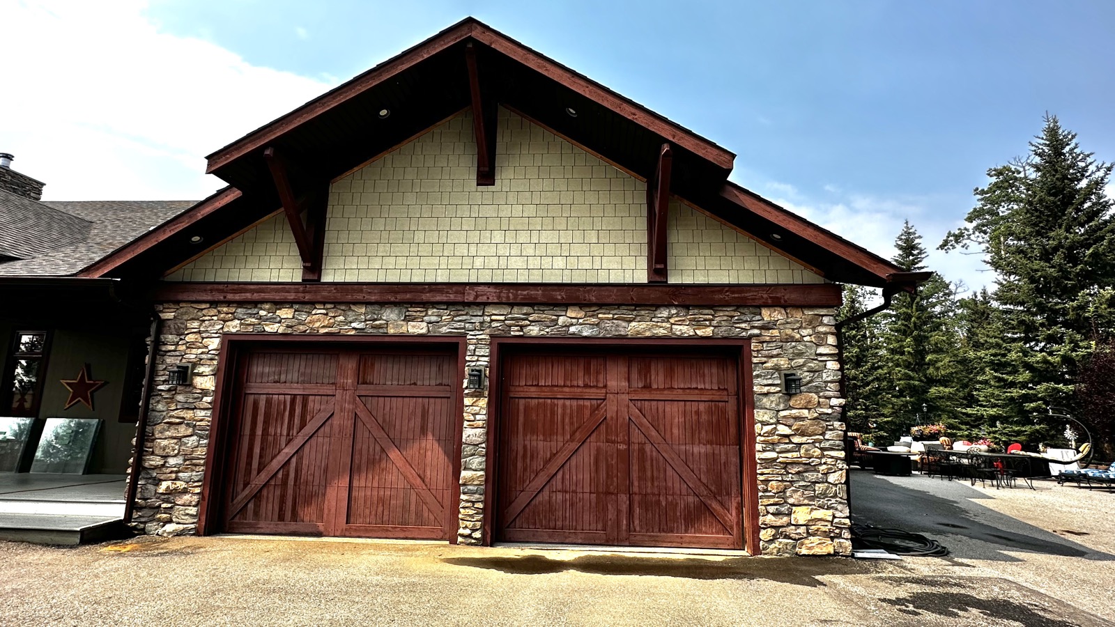 Large custom home exterior with stone and timber entry, before repaint