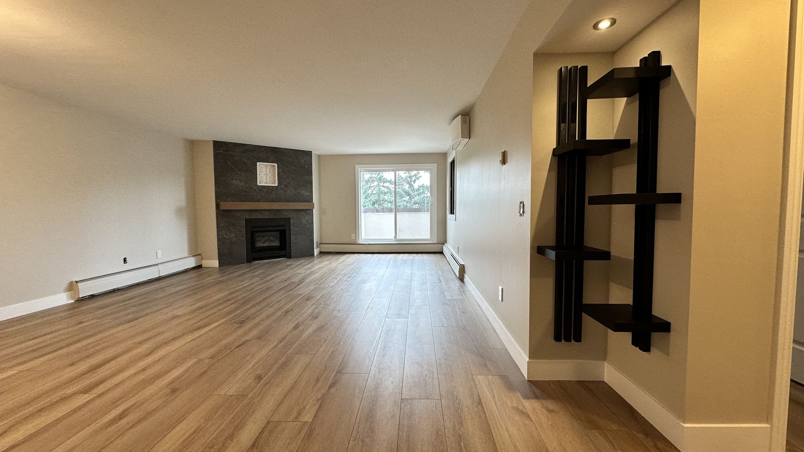 Renovated Calgary condo living room, new flooring and fireplace wall