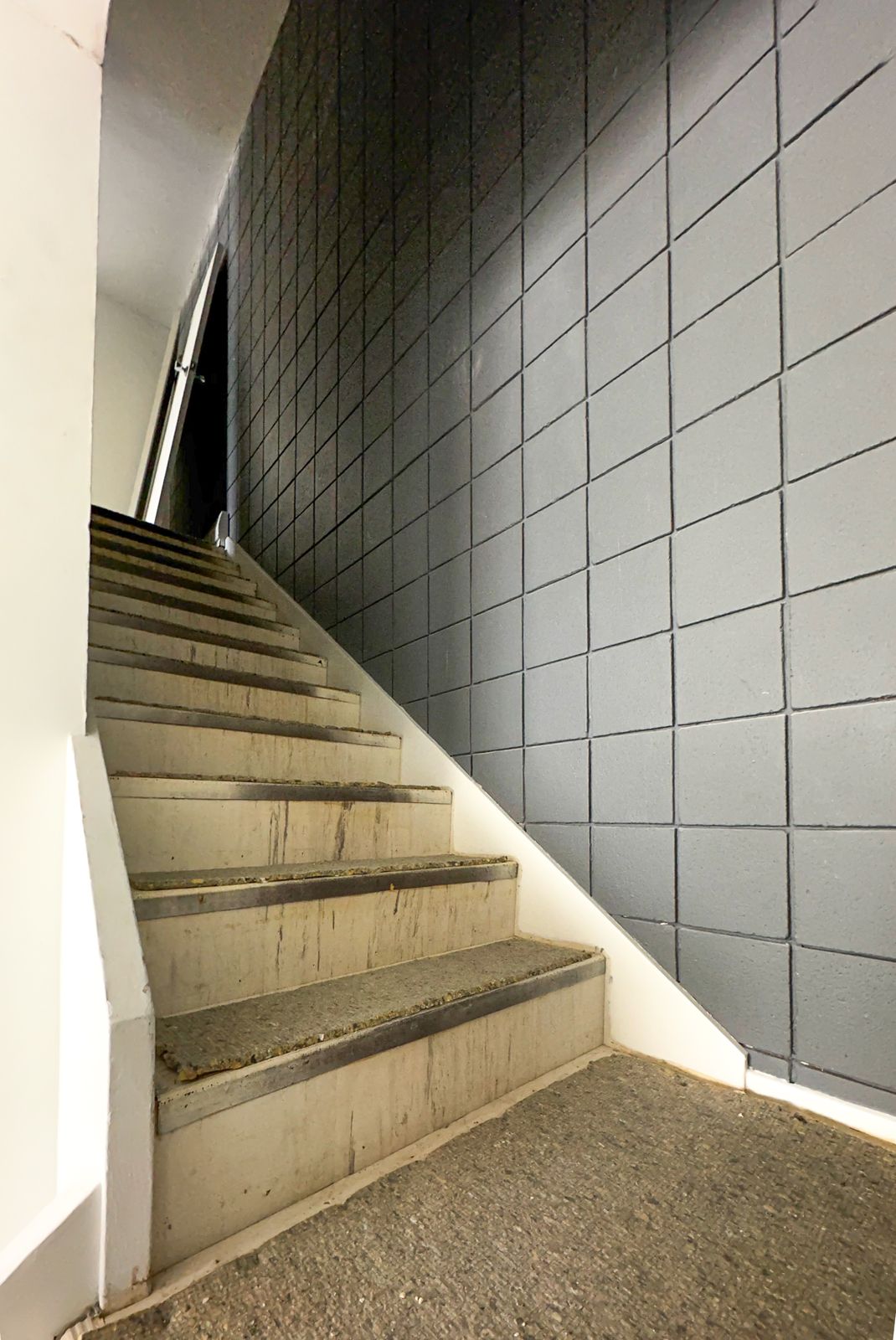 Stairwell before painting, dark tiled accent wall, Elbow Drive SW